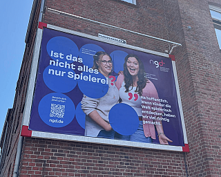 Plakat mit zwei Frauen, die über spielerisches Lernen sprechen.