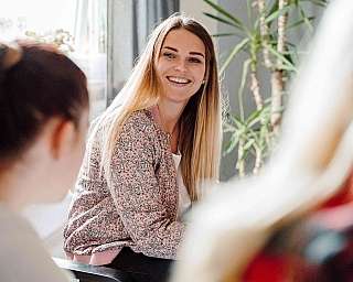 Frau am Schreibtisch schaut zum Kollegen