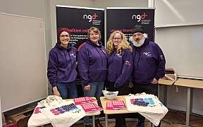 Kolleginnen und Kollegen vor Messe Roll-Ups